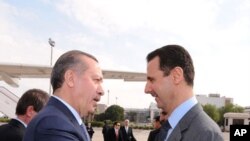 ປ. Bashar al-Assad ແຫ່ງຊີເຣຍ (ຂວາ) ຕ້ອນຮັບນາຍົກລັດຖະມົນຕີ Tayyip Erdogan ແຫ່ງເທີກີ ທີ່ສະໜາມບິນນະຄອນຫລວງ Damascus,
ວັນທີ 17 ມັງກອນ 2011.