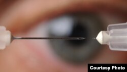 A microneedle used to inject glaucoma medications into the eye is shown next to a conventional hypodermic needle. (Georgia Tech Photo: Gary Meek)