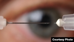 A microneedle used to inject glaucoma medications into the eye is shown next to a conventional hypodermic needle. (Georgia Tech Photo: Gary Meek)