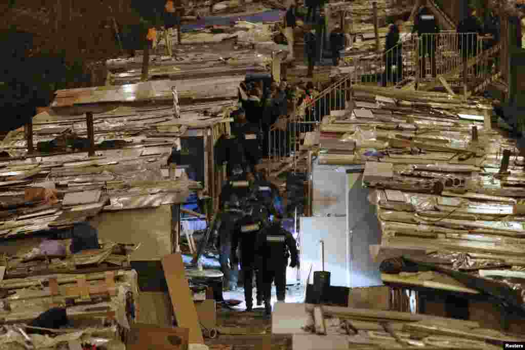 French gendarmes patrol the area as people are evacuated from a Romani camp installed along La Petite Ceinture, an abandoned railroad line, in Paris, France. More than 350 Roma people, who have been living there since last summer, were evicted from the makeshift camp.