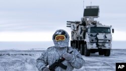 In this photo taken on April 3, 2019, a Russian solder stands guard near a Pansyr-S1 air defense system on the Kotelny Island, part of the New Siberian Islands archipelago located between the Laptev Sea and the East Siberian Sea, Russia. 