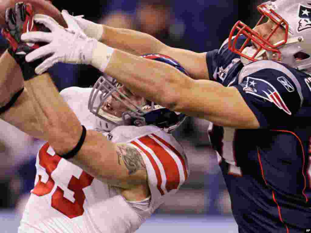 New York Giants linebacker Chase Blackburn, left, intercepts a pass intended for New England Patriots tight end Rob Gronkowski during the second half of the NFL Super Bowl XLVI football game, Sunday, Feb. 5, 2012, in Indianapolis.