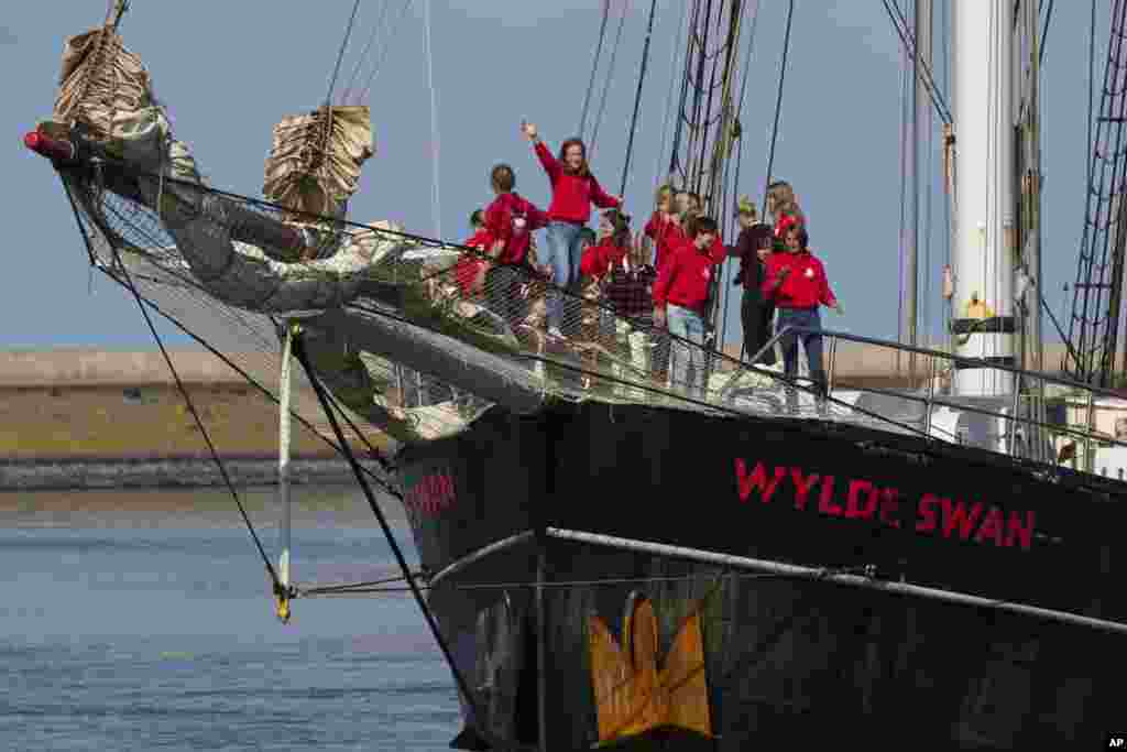 Dutch teens cheer on their schooner Wylde Swan in the port of Harlingen, northern Netherlands, after sailing home from the Caribbean across the Atlantic when coronavirus lockdowns prevented them flying.