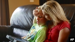 FILE - A mother is seen with her 11-year-old autistic son.