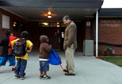 Siswa disambut oleh Pengawas Distrik Sekolah Mahnomen Jeff Bisek di Sekolah Dasar Mahnomen di Mahnomen, Minnesota. (Foto: REUTERS/Dan Koeck)