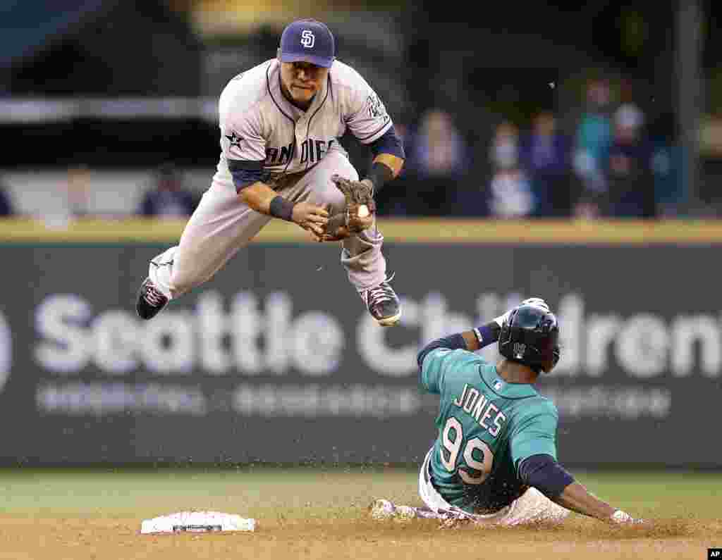 San Diego Padres second baseman Alexi Amarista leaps to get out of the way of sliding Seattle Mariners&#39; James Jones (99) at second base in the fourth inning in a baseball game in Seattle, Washington, USA, June 16, 2014.