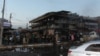 FILE - Iraqi people gather at the site where a car bomb exploded in a crowded street in the Iraqi city of Tikrit, March 15, 2017. 