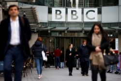 Pejalan kaki berjalan melewati logo BBC di Broadcasting House, di London, Inggris, 29 Januari 2020. (Foto: REUTERS/Henry Nicholls)