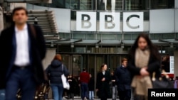 FILE - Pedestrians walk past a BBC logo at Broadcasting House in London, Britain, Jan. 29, 2020. 