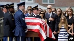 FILE - Vice President Joe Biden, accompanied by his family, watches an honor guard carry a casket containing the remains of his son Beau Biden into a funeral service at St. Anthony of Padua Roman Catholic Church in Wilmington, Del., June 6, 2015. 