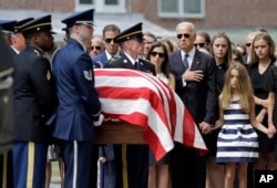 Vice President Joe Biden, accompanied by his family, watches an honor guard carry a casket containing the remains of his son Beau Biden into a funeral service at St. Anthony of Padua Roman Catholic Church in Wilmington, Del., June 6, 2015.