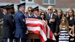 FILE - Vice President Joe Biden, accompanied by his family, watches an honor guard carry a casket containing the remains of his son Beau Biden into a funeral service at St. Anthony of Padua Roman Catholic Church in Wilmington, Del., June 6, 2015.
