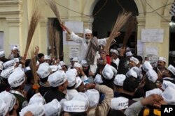 India’s Aam Aadmi Party, or Common Man's Party, supporters with brooms, the party symbol, celebrate the party’s performance in Delhi state Assembly elections, in New Delhi, Dec. 8, 2013.