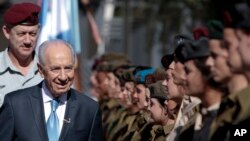 Israeli President Shimon Peres, second left, surveys the honor guard with Israeli Defense Forces Chief of Staff Benny Ganz, left, during Israel's 63rd Independence Day event at his residence, in Jerusalem, Tuesday, May 10, 2011.