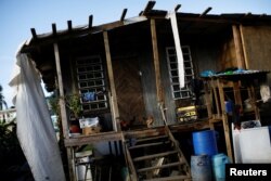 Chickens stand at the entrance to a house, which was partially destroyed by Hurricane Maria, at the squatter community of Villa Hugo in Canovanas, Puerto Rico, Dec. 11, 2017.