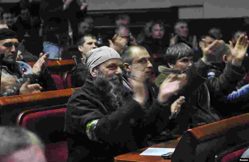 Pro-Russian activists applaud during voting in the regional government building in Donetsk, Ukraine, April 7, 2014. 