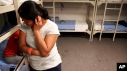 FILE - An unidentified Guatemalan woman and a child are seen inside a dormitory in the Artesia Family Residential Center, a federal detention facility for undocumented immigrant mothers and children in Artesia, New Mexico, Sept. 10, 2014.