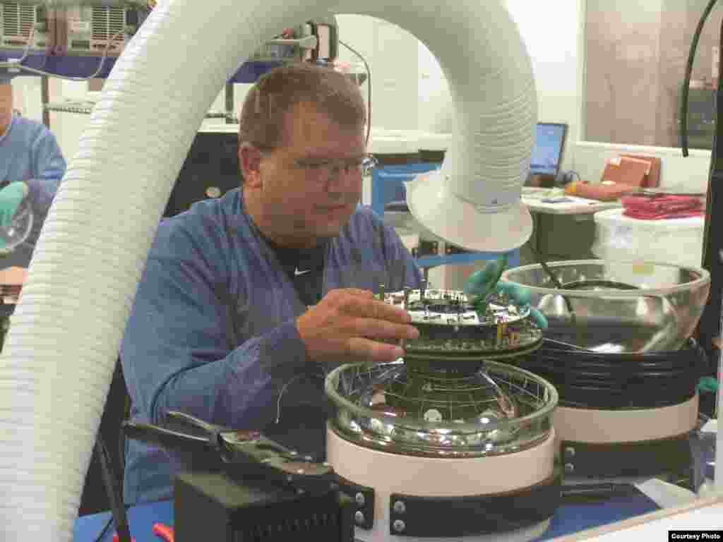 A technician at the University of Wisconsin-Madison Physical Sciences Lab works on one of the sensors of the IceCube detector. (IceCube/NSF)