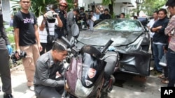 In this Sept. 3, 2012, photo, a Ferrari, that was driven by Vorayuth Yoovidhya, a grandson of late Red Bull founder Chaleo Yoovidhya, and a motorcycle, both involved in an accident, are displayed by police in Bangkok, Thailand.