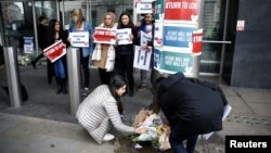 People lay flowers outside New Zealand House, following the Christchurch mosque attacks in New Zealand, in London, March 15, 2019.