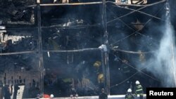 Bomberos trabajan en la bodega que se incendió el viernes en el distrito Fruitvale, de Oakland, California.