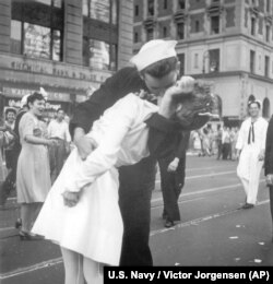 FILE - In a photo provided by the U.S. Navy, a sailor and a woman kiss in New York's Times Square, as people celebrate the end of World War II, Aug. 14, 1945. George Mendonsa was the young sailor in the photo.