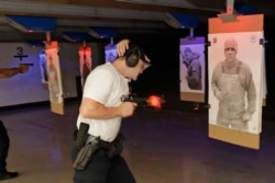 FILE: An officer at Washington state's Law Enforcement Academy fires his weapon as a photo of man not holding a weapon moves into view during a training class in Burien, Wash. July 16, 2019.