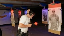 FILE: An officer at Washington state's Law Enforcement Academy fires his weapon as a photo of man not holding a weapon moves into view during a training class in Burien, Wash. July 16, 2019.