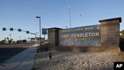 Vehicles file through the main gate of Camp Pendleton Marine Base on Wednesday, Nov. 13, 2013.