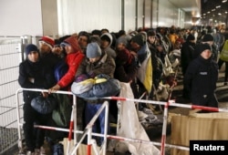 Migrants queue on a street to enter the compound outside the Berlin Office of Health and Social Affairs (LAGESO) for their registration process in Berlin, Germany, in this Dec. 9, 2015 file picture.