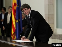 Catalan President Carles Puigdemont signs a declaration of independence at the Catalan regional parliament in Barcelona, Spain, Oct. 10, 2017.