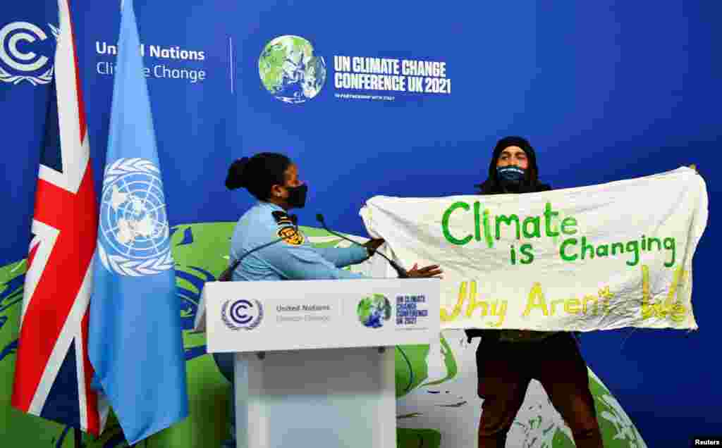 A protester holds a banner during the U.N. Climate Change Conference (COP26) in Glasgow, Scotland, Nov. 13, 2021.