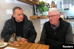 Peter Blenkiron and Philip Nagle react as they sit in a cafe in Cardinal George Pell's hometown, just days before the Vatican treasurer's first court appearance on historic sex charges, in the town of Ballarat, located west of the southern city of Melbourne, Australia, July 24, 2017.