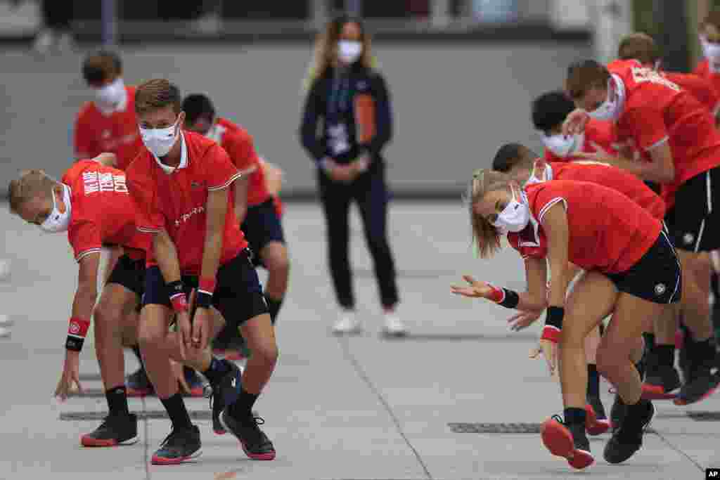 Ball girls and boys exercise before the second round matches of the French Open tennis tournament at the Roland Garros stadium in Paris, France.