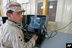 FILE - An Iraqi soldier practices using a robot during a bomb disposal training for the Iraqi security forces at a Besmaya range complex just outside Baghdad, Nov. 17, 2008.