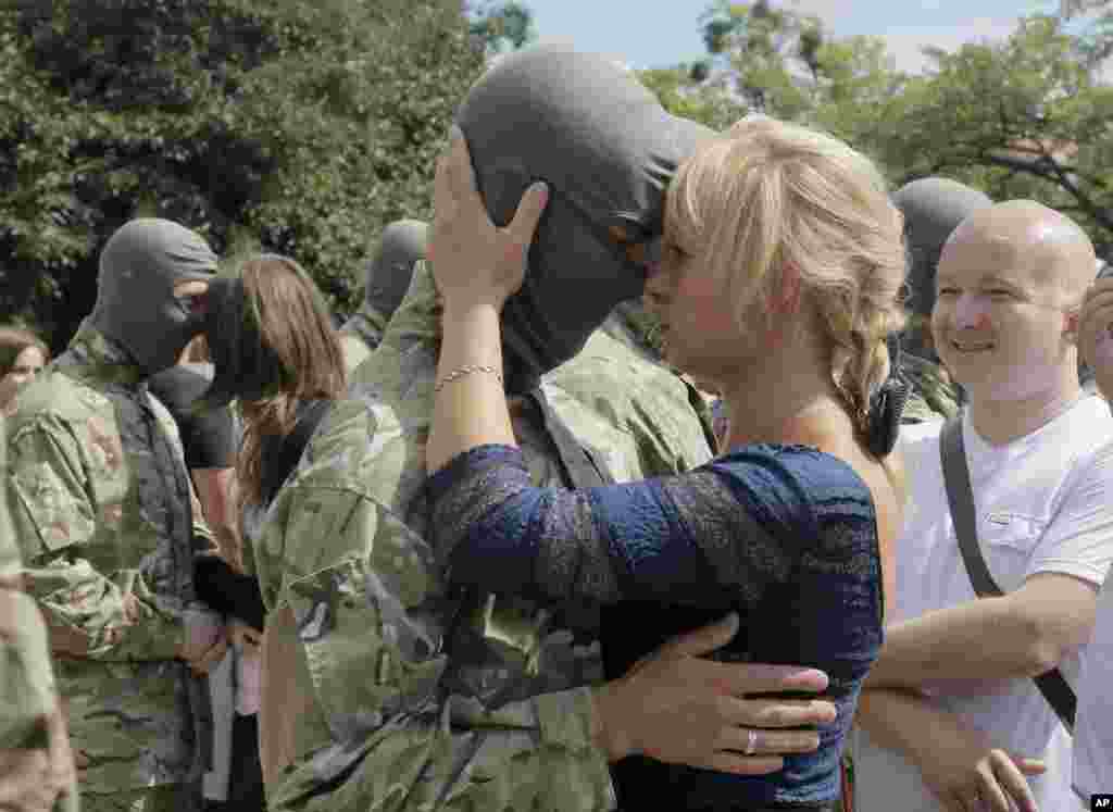Friends and relatives say goodbye to volunteers before they are sent to the eastern part of Ukraine to join the ranks of a special battalion &quot;Azov,&quot; fighting against pro-Russian separatists, in Kyiv, Ukraine, Aug. 17, 2014.