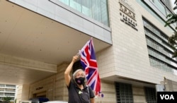香港社运人士王婆婆9月23日在西九龙裁判法院大楼外，高举英国旗声援民主派初选47人案的被告 (美国之音/汤惠芸)