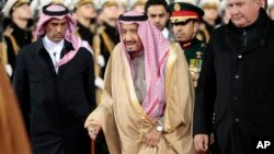 Saudi King Salman, center, and Russian Deputy Prime Minister Dmitry Rogozin, right, review the honor guard upon their arrival at Moscow's Vnukovo airport, Russia, Oct. 4, 2017. 