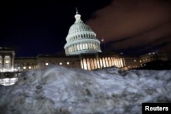 Gedung Capitol tampak dari balik tumpukan salju di Washington, 16 Januari 2019.