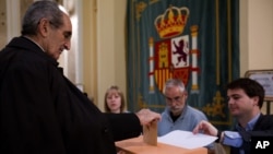 Seorang pria memasukkan kartu suara dalam pemilu legislatif Spanyol di Madrid, Minggu (20/12).