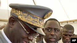 Senegal's newly inaugurated President Macky Sall (R) is surrounded by security as he leaves his swearing-in ceremony at a hotel in Dakar, April 2, 2012