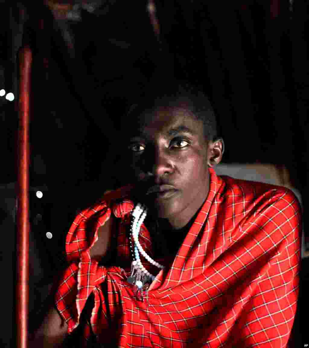 Un membre de la tribu Maasai pose pour une photo à lla maison de ses parents dans un village à la périphérie de Serengeti, dans le nord de la Tanzanie, lundi 12 août 2013 photo.