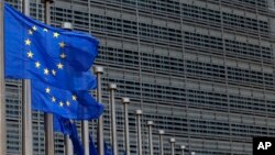 FILE - European Union flags set of half staff outside the European Commission headquarters in Brussels, Belgium.