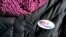 FILE - A woman wears an "I voted" sticker after voting in Massachusetts' primary election in the East Boston neighborhood of Boston, March 1, 2016. 