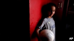 Candelaria Cabrera, 7, poses for a portrait holding a soccer ball in Chabas, Argentina, Sept. 8, 2018. She was 3 years old when her parents gave her her first ball. Her desire to play soccer has called attention to the obstacles women face in the sport in Argentina.