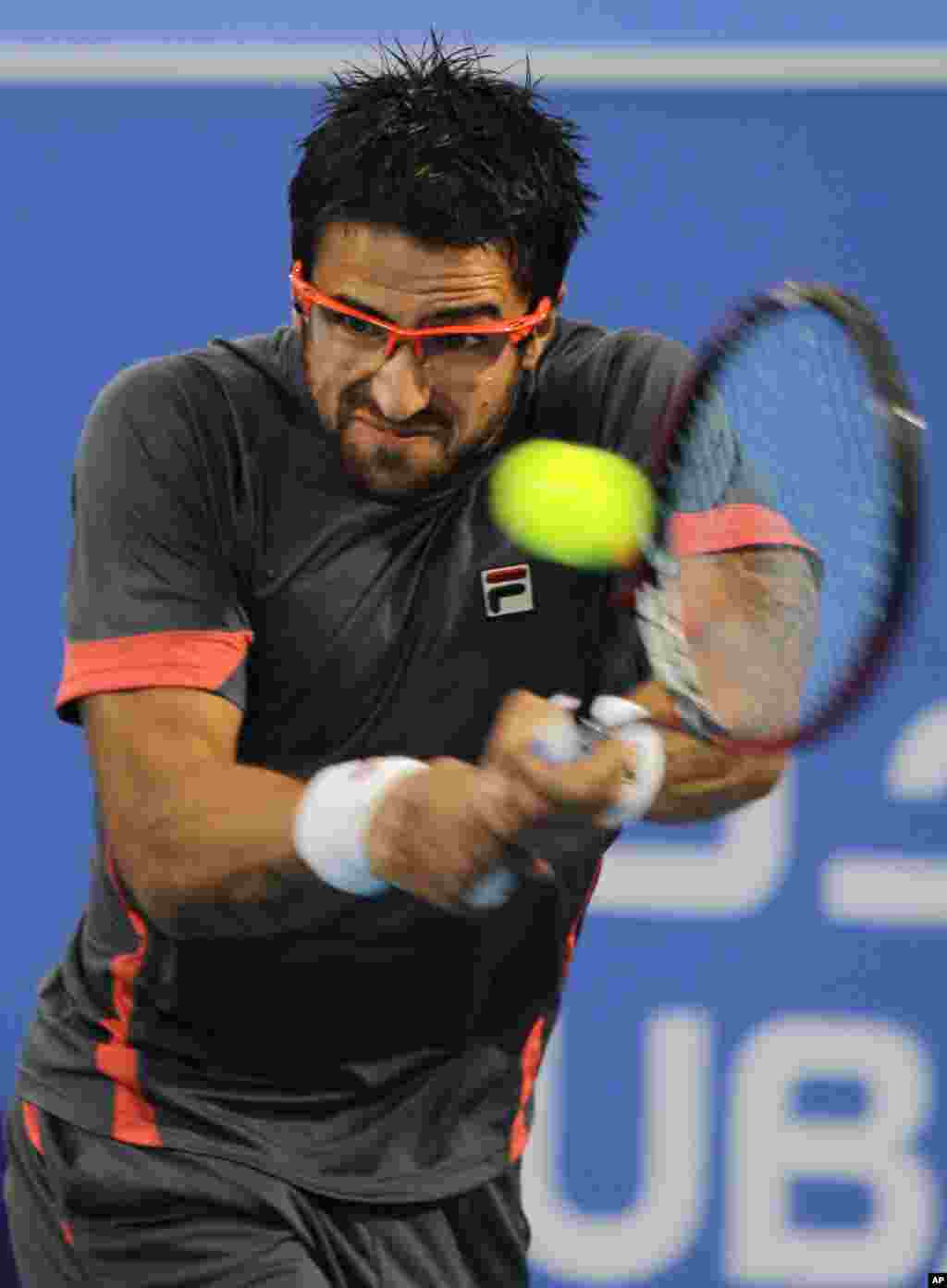 Serbia's Janko Tipsarevic returns the ball to Andy Murray from Britain during the first day of Mubadala Tennis Championship in Abu Dhabi, United Arab Emirates, Thursday, Dec. 27.