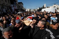 Mourners carry the body of Palestinian Yazan Abu Tabekh, who was killed during an Israeli raid, during his funeral in Jenin in the Israeli-occupied West Bank, Feb. 6, 2020.