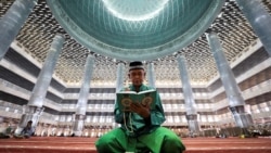 <p>Seorang pria Muslim membaca Al-Qur'an di Masjid Agung Istiqlal selama bulan puasa Ramadan di Jakarta. (Reuters) 