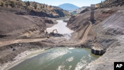 This image provided by Swiftwater Films shows a downstream view of crews working at the Iron Gate coffer dam site along the Klamath River on Tuesday, Aug. 27, 2024, in Siskiyou County, Calif.