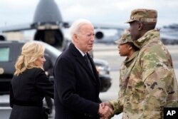 FILE - President Joe Biden and first lady Jill Biden greet service members before boarding Air Force One after attending a casualty return for three US soldiers at Dover Air Force Base, Del., February 2, 2024.